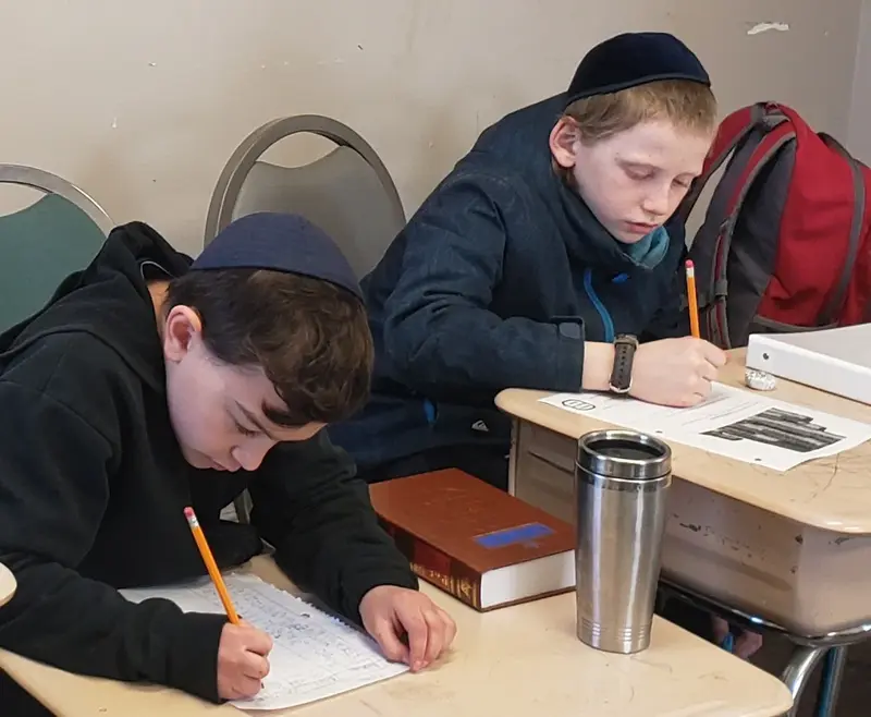 Two boys writing at their desks